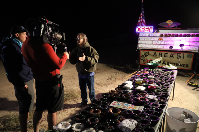 A film crew interviews an Area 51 ashtray vendor.